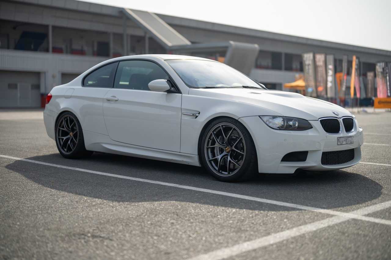 A white modified BMW M3 E92 in a parking lot | ATOMIC-SHOP