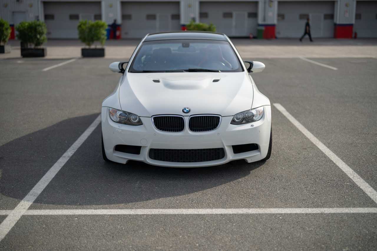 A white modified BMW M3 E92 in a parking lot | ATOMIC-SHOP